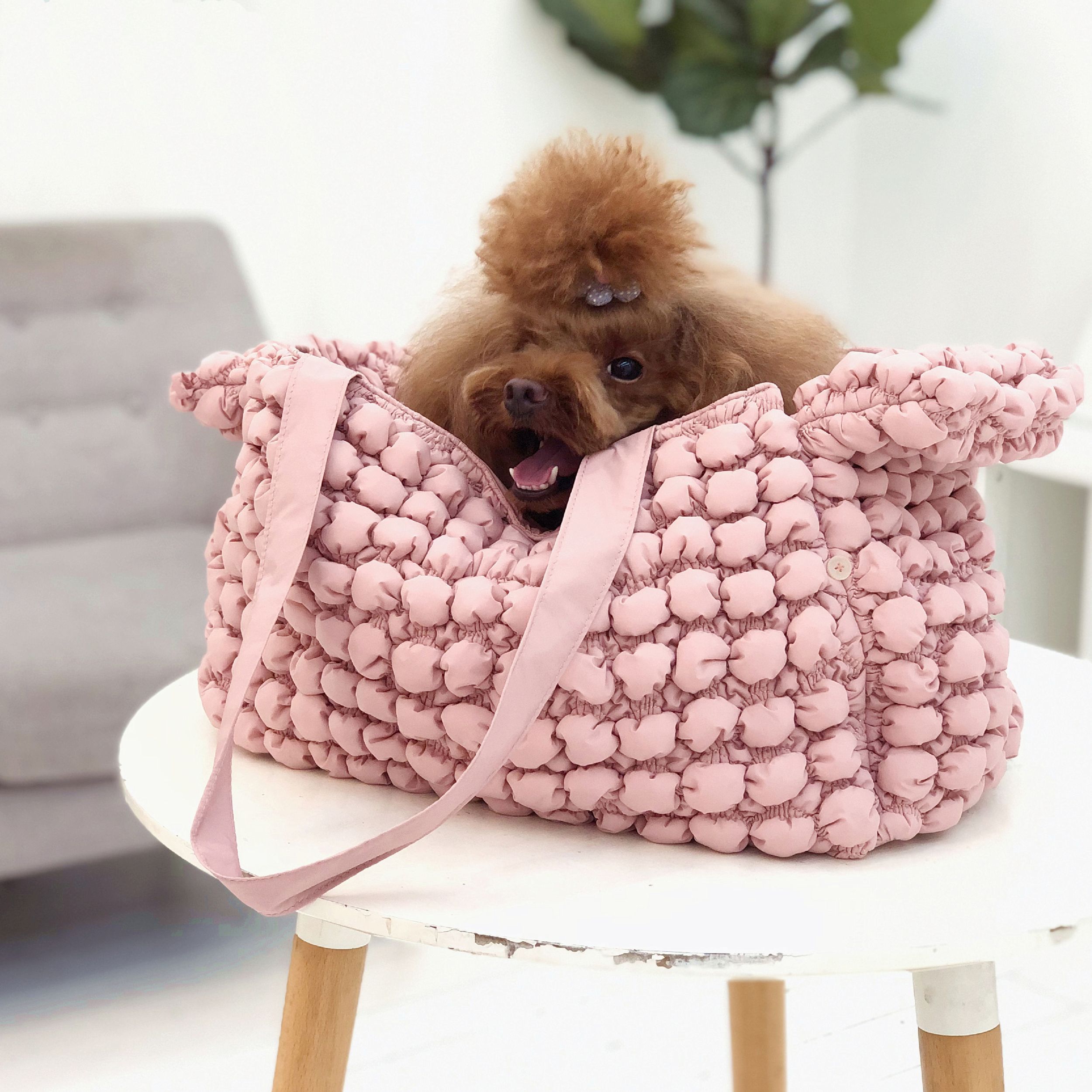 Pink ultra-plush pet carrier with bubble texture; dog sitting inside with paws out.