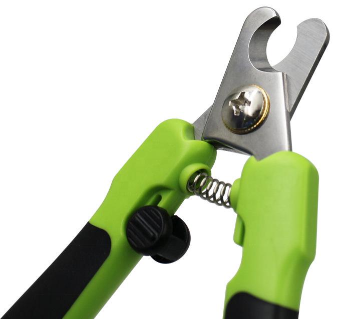 Close-up of spring and finger grip on green and black pet nail clipper with file
