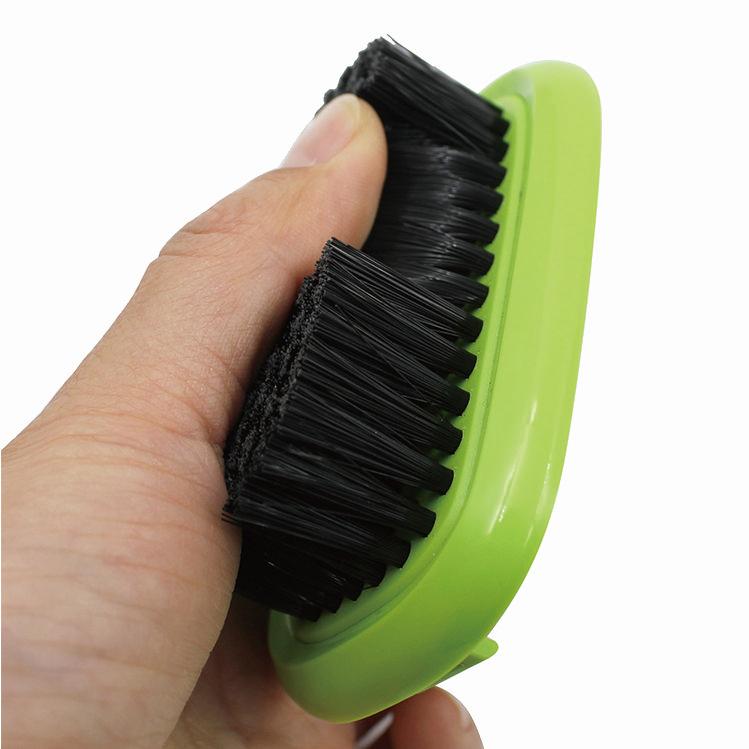 Close-up of green grooming brush showing dense black bristles