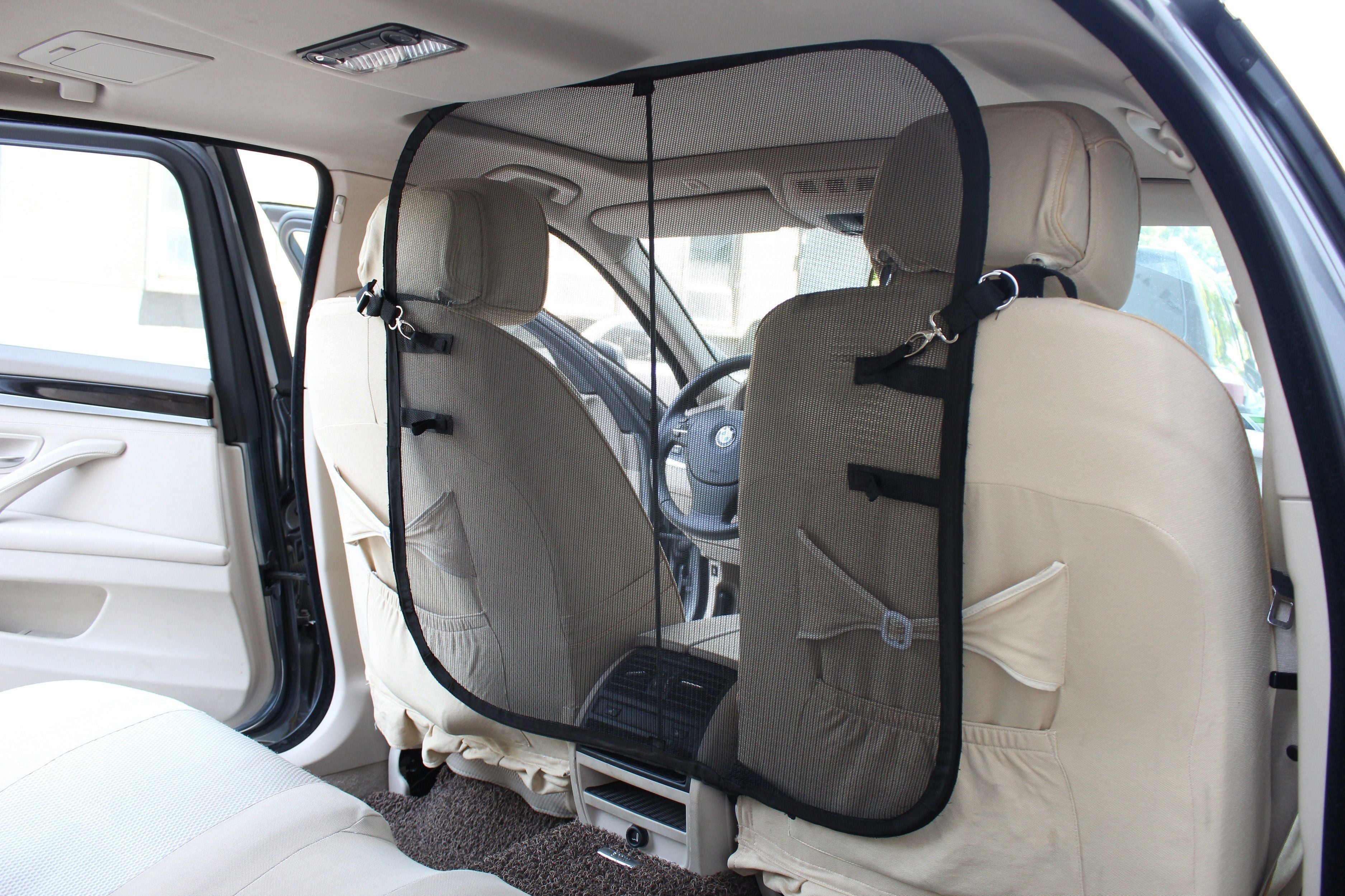 Gray mesh backseat safety barrier with hook straps, attached between car seats