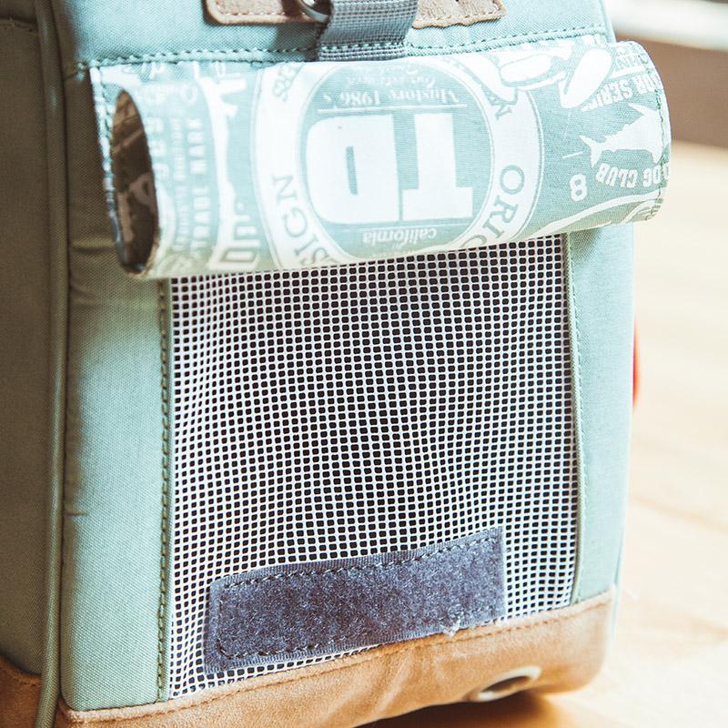 Light blue pet carrier side panel with mesh ventilation pocket and fabric label