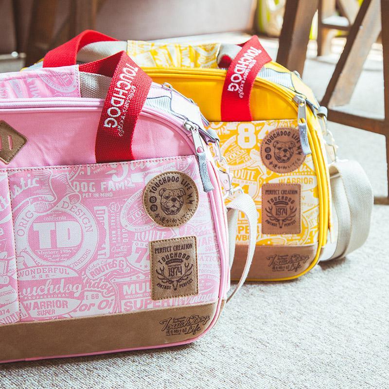 Pink and yellow pet carrier duffels with red straps and front zipper details
