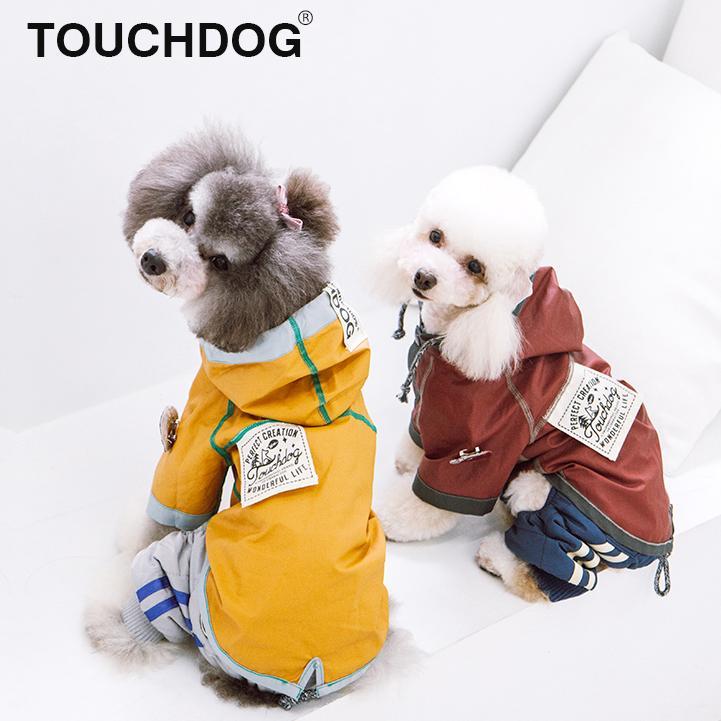 Two small dogs wearing hooded reversible raincoats in yellow and burgundy-red colors