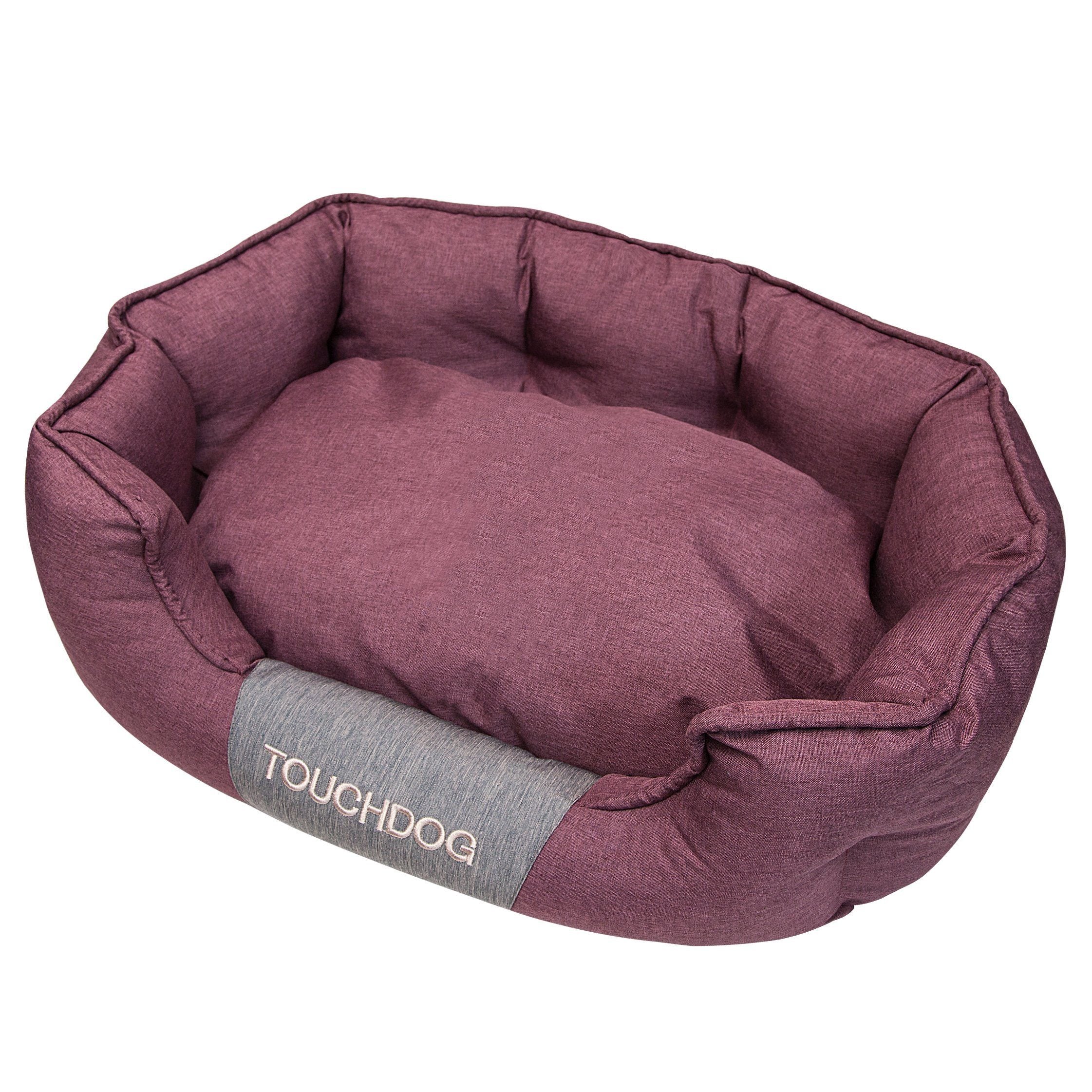 Pink oval dog bed with padded sides and cushioned base, water-resistant fabric