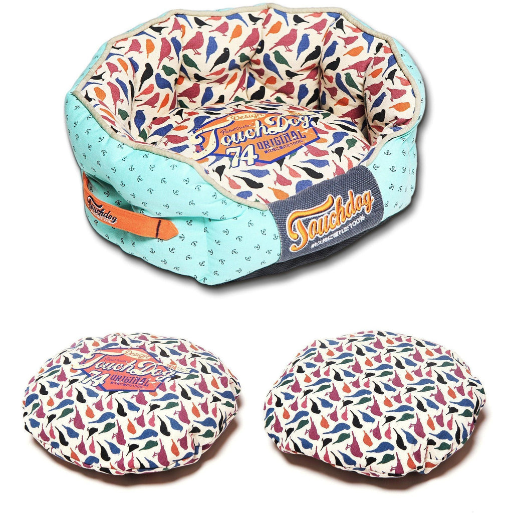 Rounded dog bed with light blue outer fabric, bird-print center, “Original 74” label
