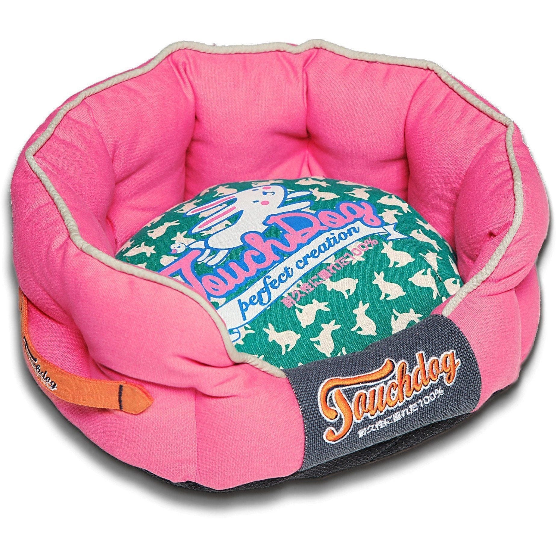 Pink rounded dog bed with teal rabbit-pattern cushion and navy “Sauchdog” logo