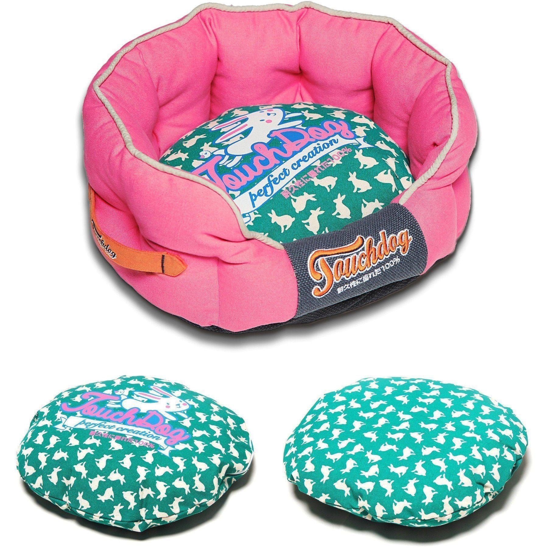 Pink rounded dog bed with teal rabbit-spotted cushion and navy logo panel