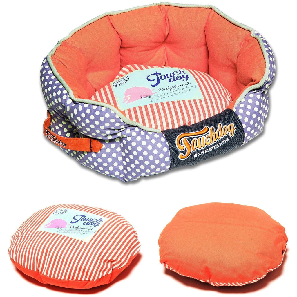 Rounded dog bed with purple polka-dot sides, coral interior, striped insert, orange accent