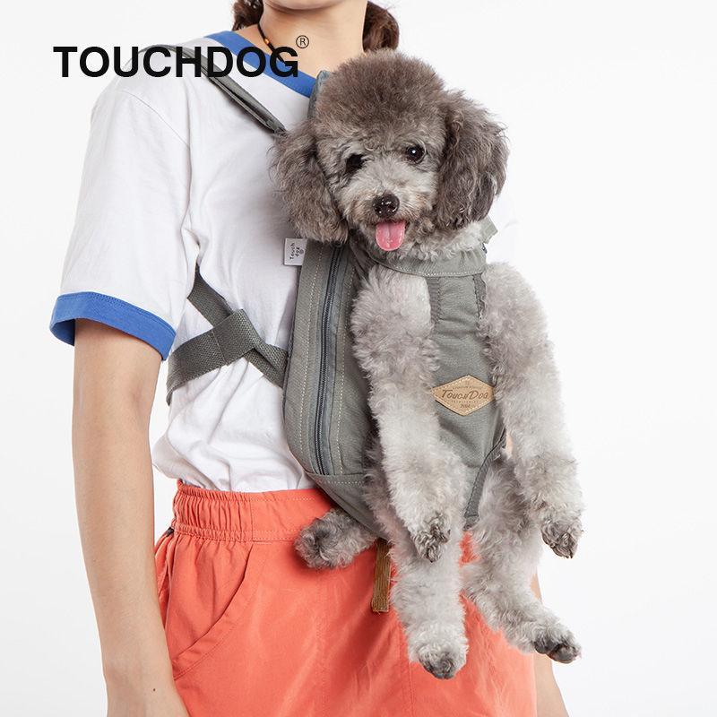 Gray backpack dog carrier with front zip and round vent openings, held close to person