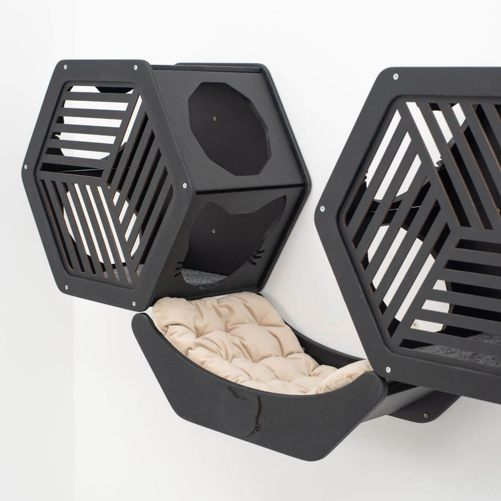 Hexagonal wall cat bed in black with slatted sides and beige cushion