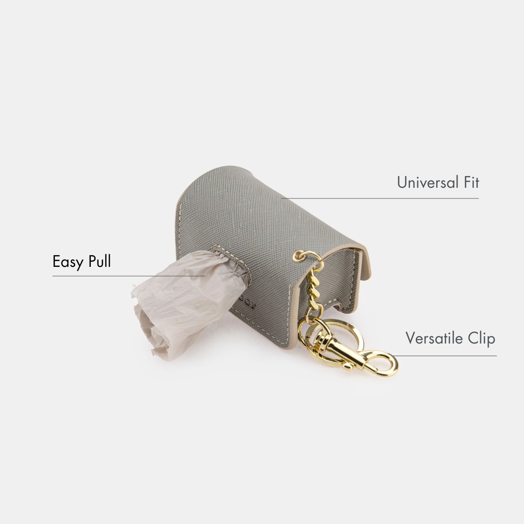 Grey waste bag dispenser case with easy-pull opening and gold clasp keyring