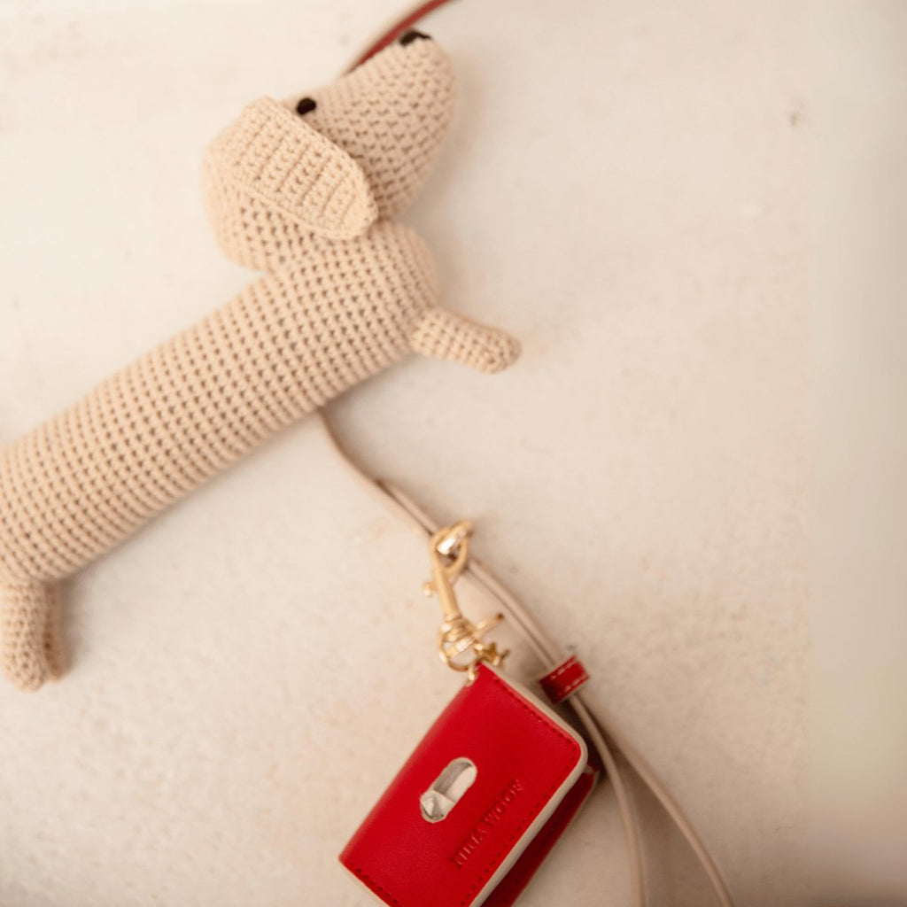 Red waste bag holder with metal ring clip and bag opening tab