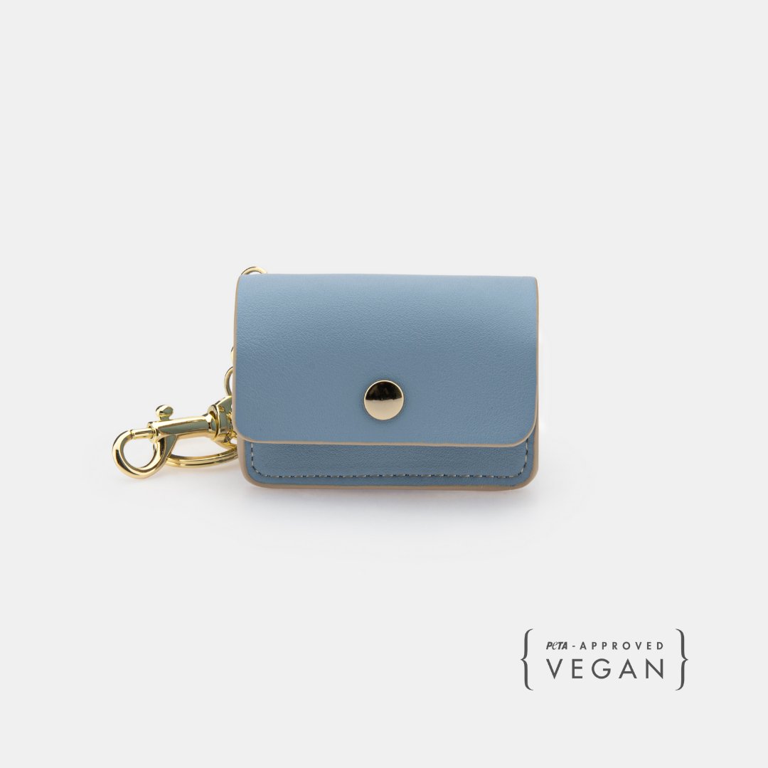 Blue waste bag holder with round snap button and gold hardware, front view